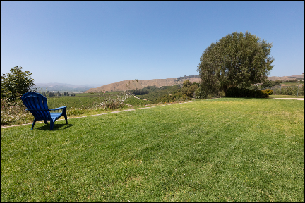 Real Estate Photo of backyard green grass with lounge chair and view (ChrisRyanPIX)