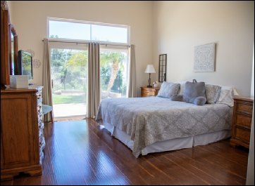 Real Estate Photo of interior bedroom with wood floors and bright light (ChrisRyanPIX)
